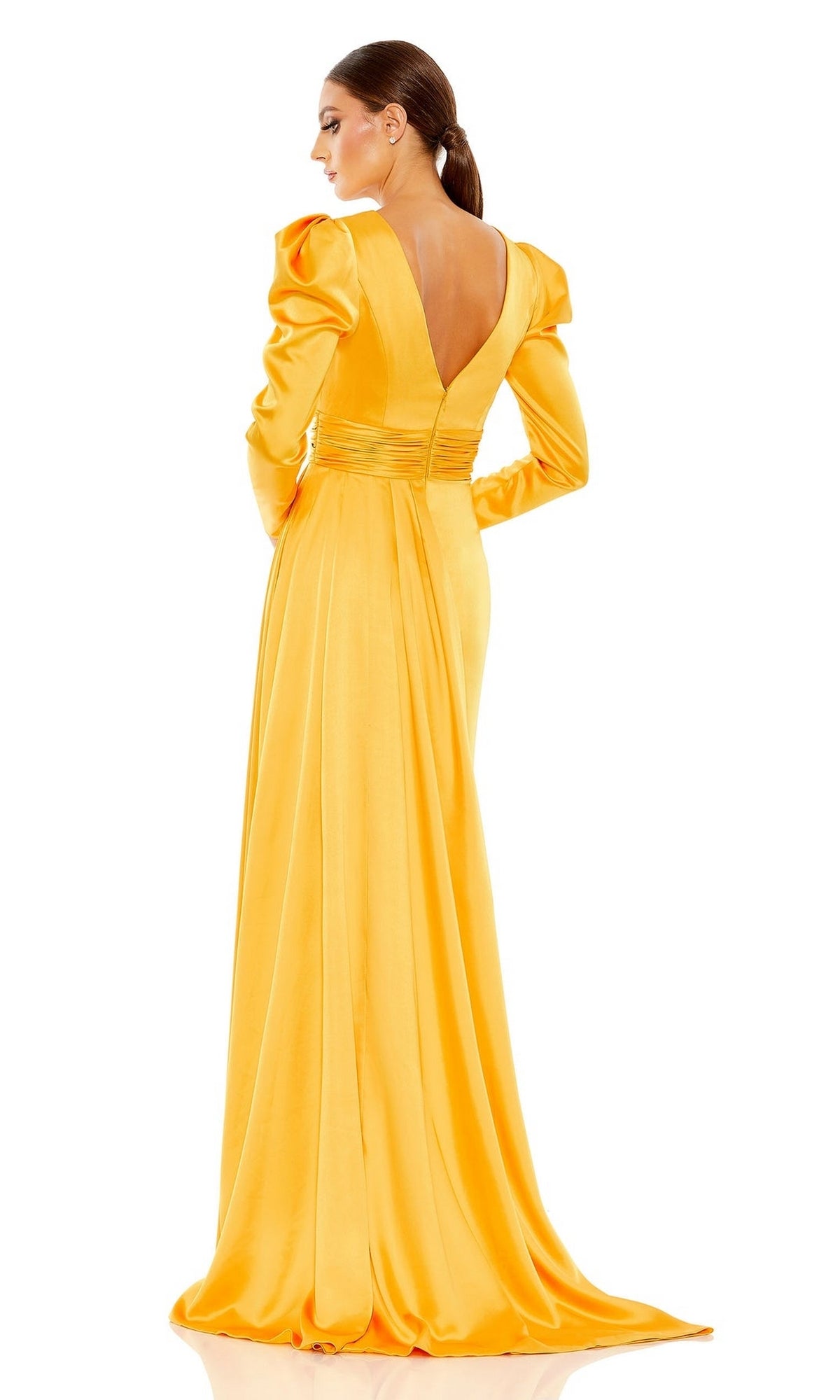 A woman faces away from the camera in the Long Formal Dress 12404 by Mac Duggal, a yellow satin, floor-length gown with long sleeves, a deep V-back, and gathered waist detailing.